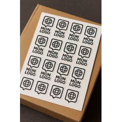 Planche d’autocollants personnalisés logo posée sur boîte en carton kraft – impression professionnelle vinyle
